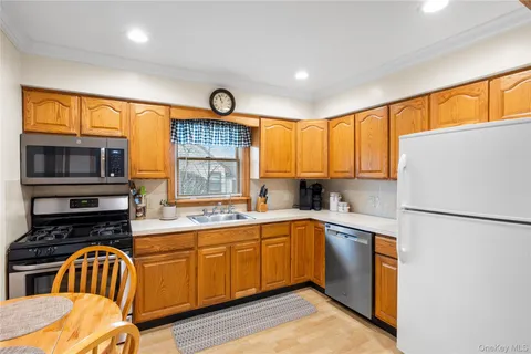 a kitchen with stainless steel appliances a sink a stove cabinets and a window