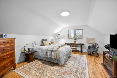 a bedroom with a bed and a flat tv screen on a dresser