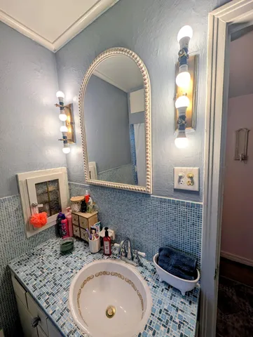 a bathroom with a granite countertop sink and a mirror