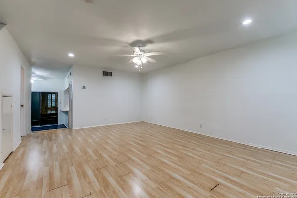 an empty room with wooden floor a fireplace and a window