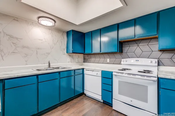 a kitchen with sink a stove and cabinets