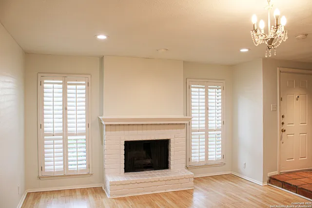 a living room with a fireplace and wooden floor