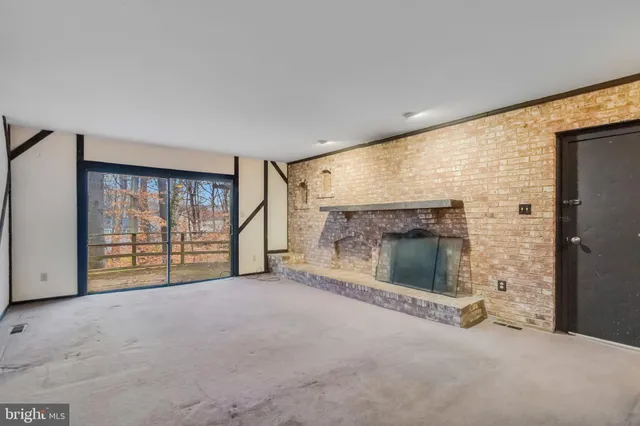 an empty room with fireplace and windows