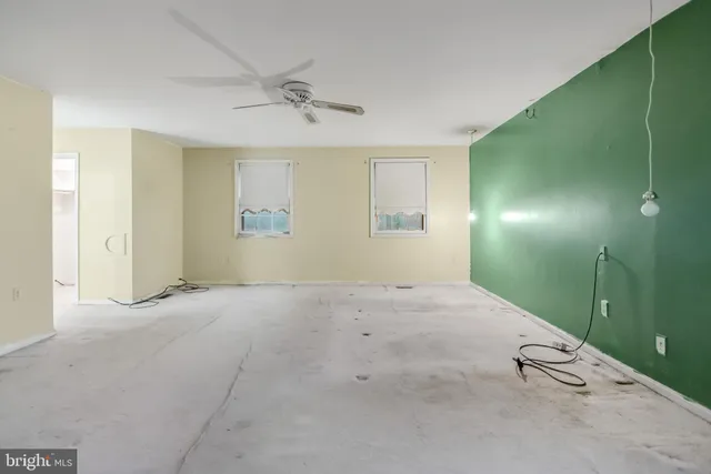 an empty room with fan and window