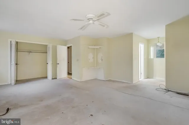 an empty room with fan and entrance