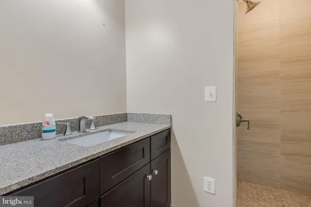 a bathroom with a granite countertop sink and a mirror