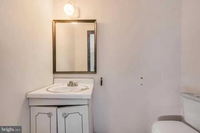a bathroom with a sink a toilet and mirror