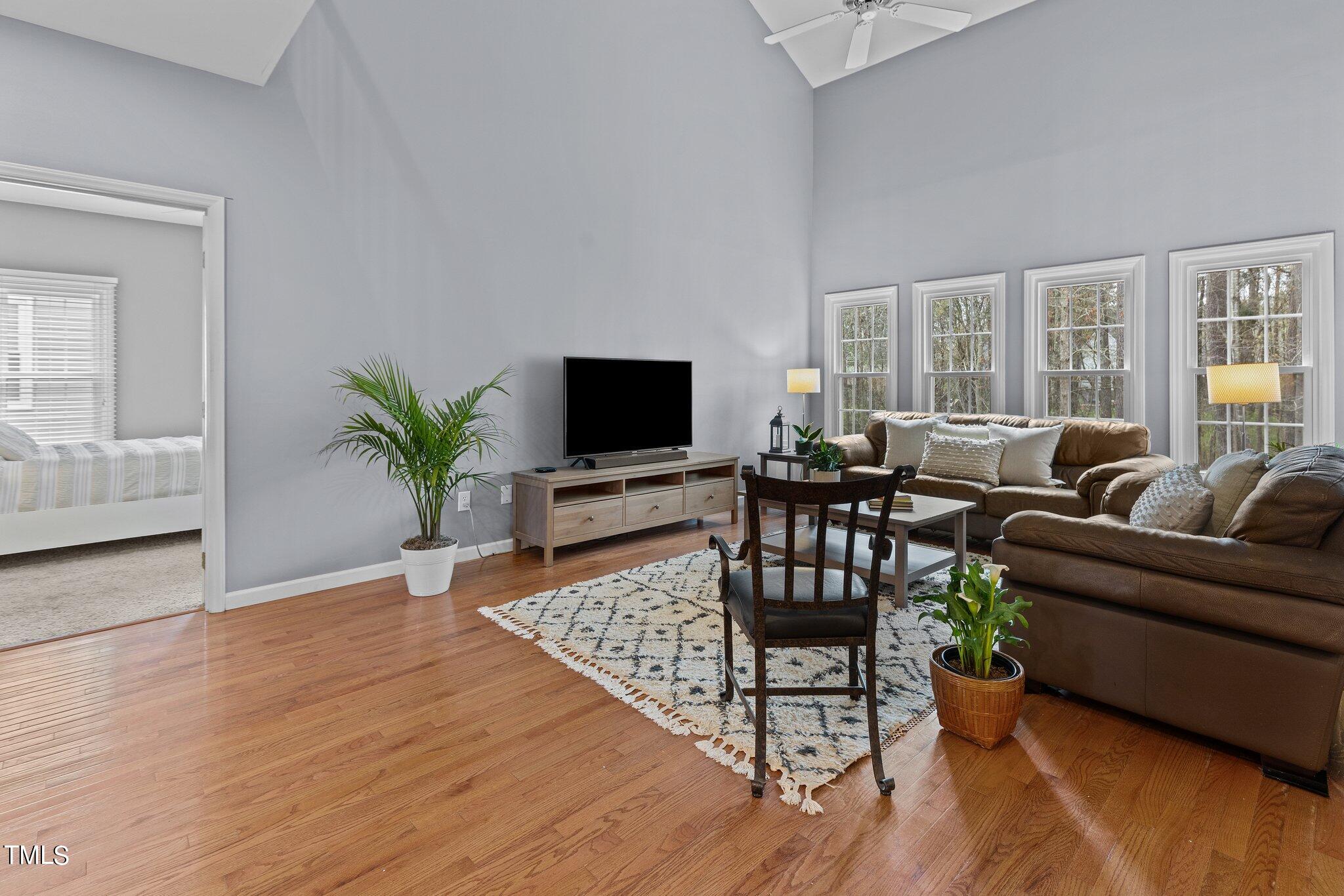 103 Summerglow Court Cary, NC 27513 - Photo 13 of 67 a living room with furniture a wooden floor and a flat screen tv