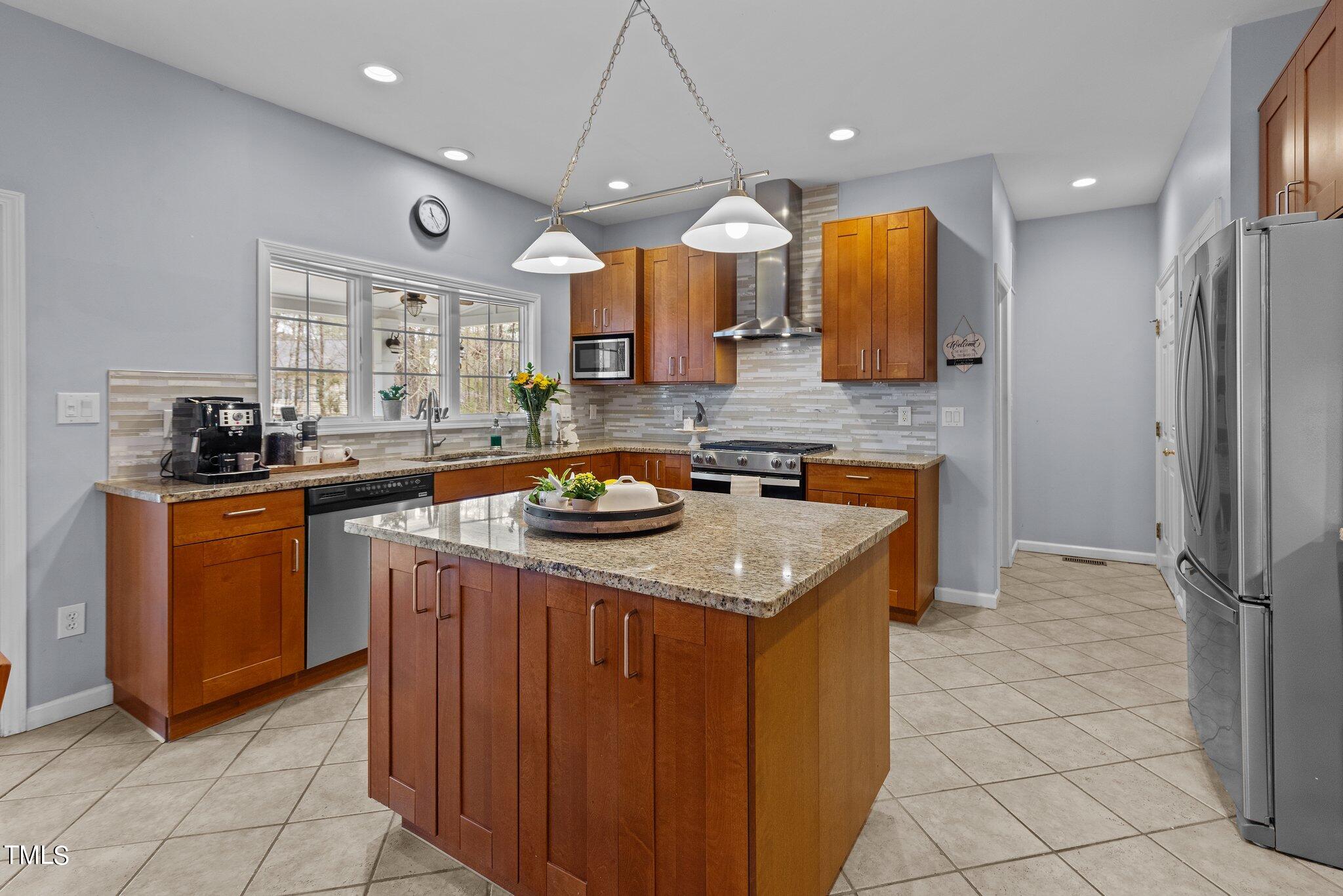103 Summerglow Court Cary, NC 27513 - Photo 20 of 67 a kitchen with stainless steel appliances granite countertop a sink a counter top space cabinets and stainless steel appliances