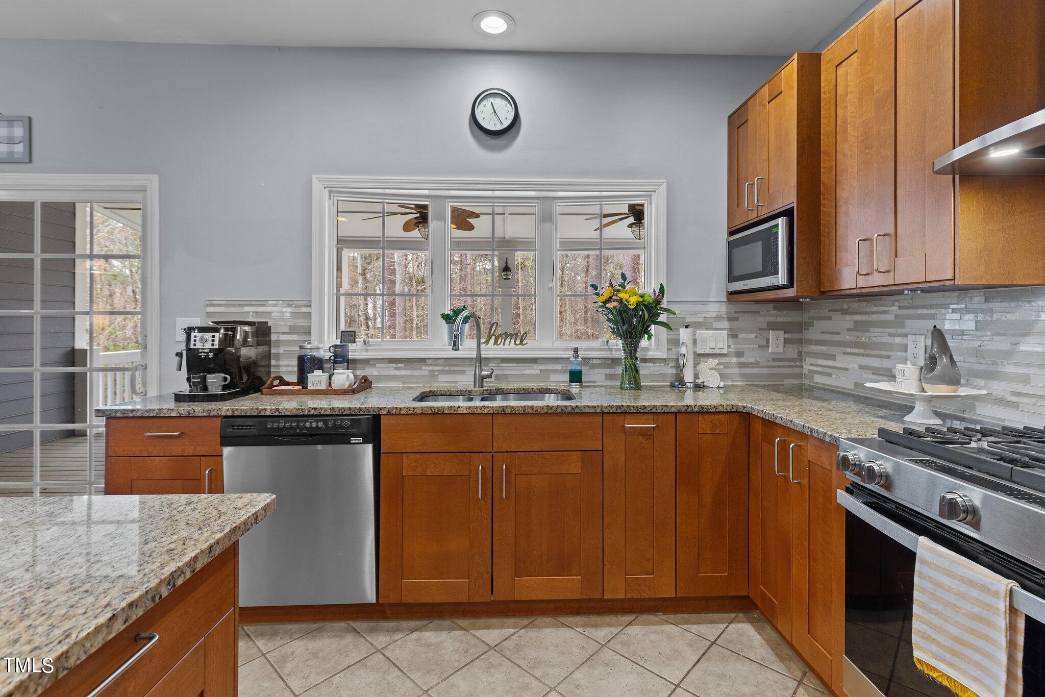 103 Summerglow Court Cary, NC 27513 - Photo 22 of 67 a kitchen with stainless steel appliances granite countertop a sink stove and cabinets