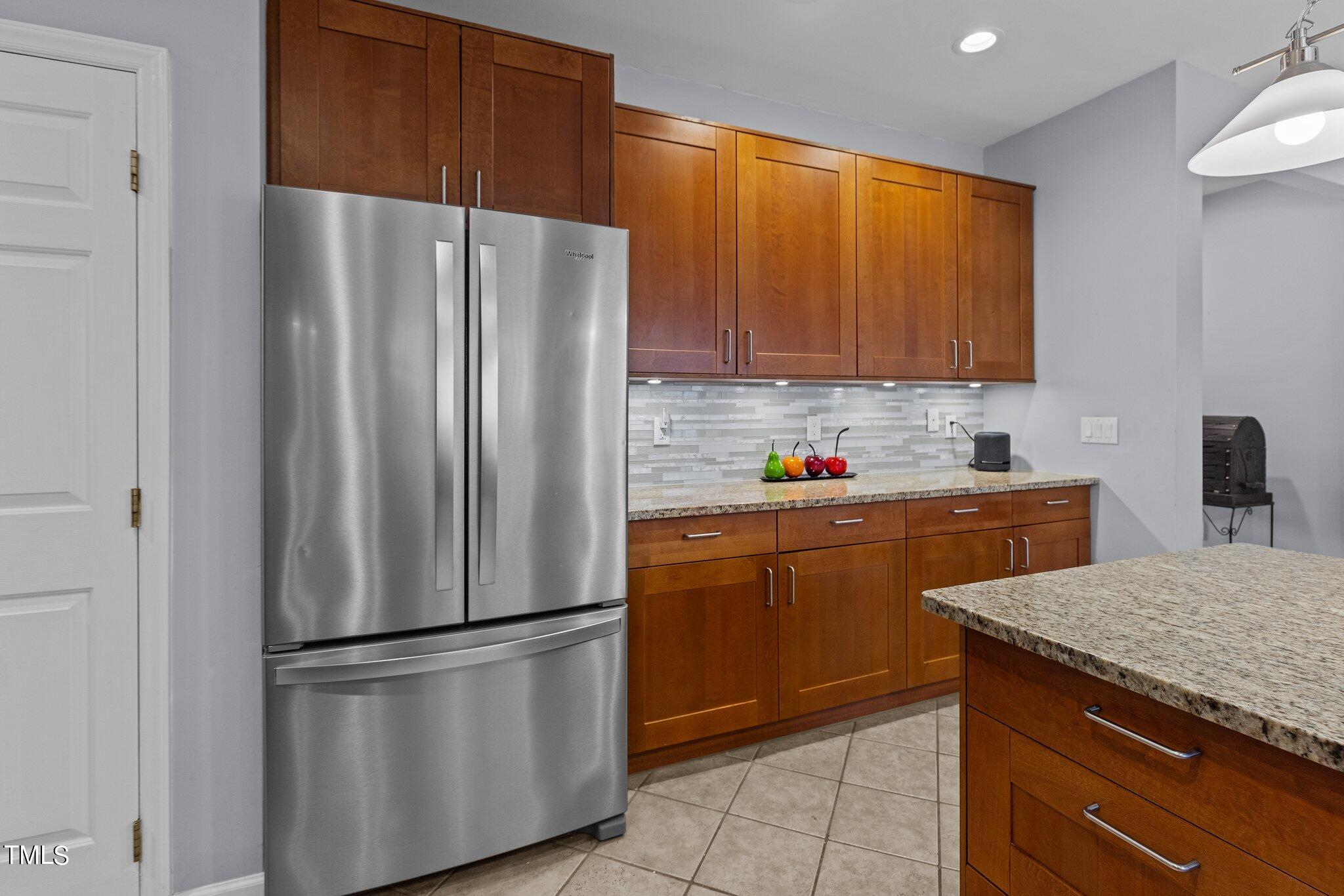 103 Summerglow Court Cary, NC 27513 - Photo 24 of 67 a kitchen with stainless steel appliances granite countertop a refrigerator sink and cabinets