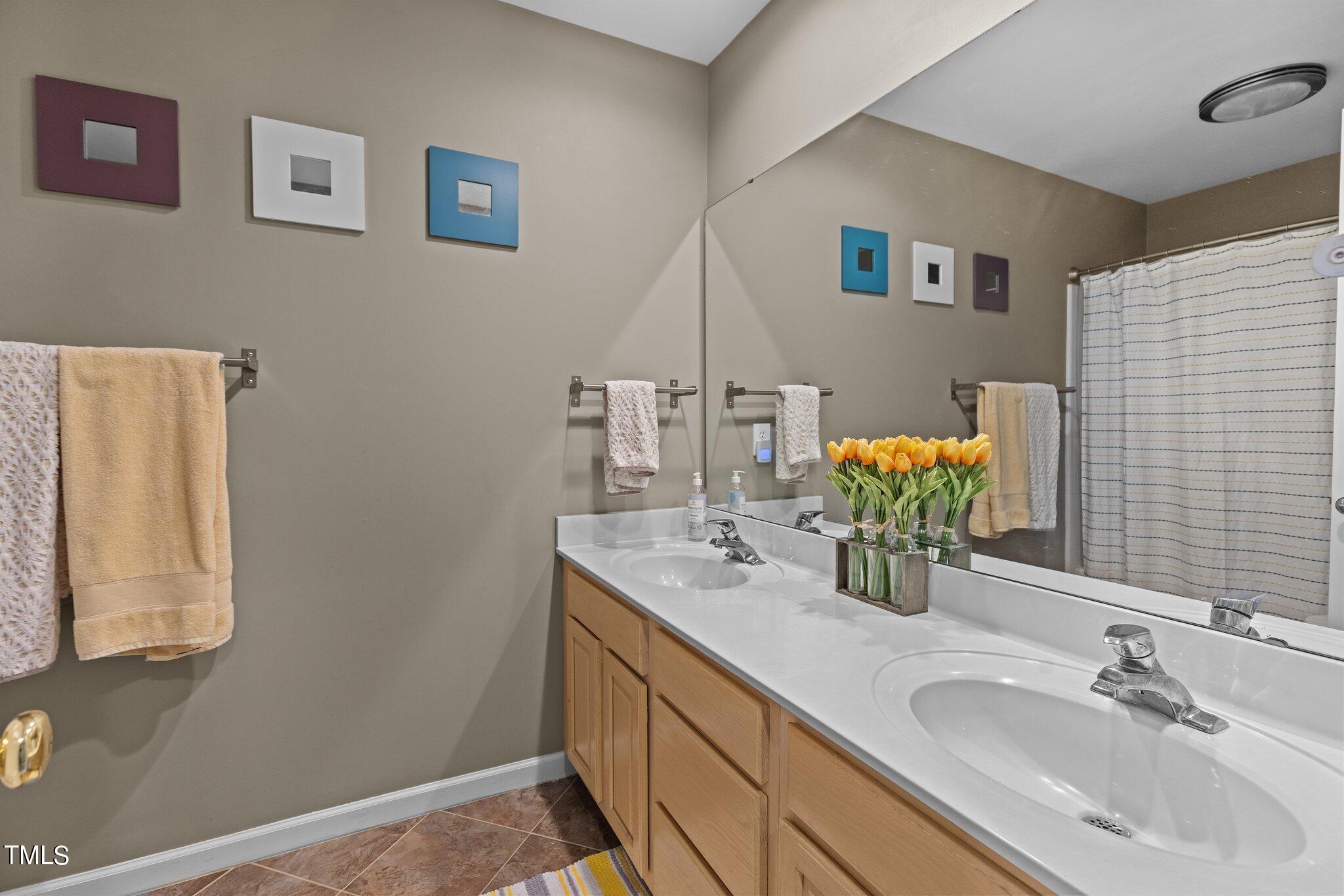 103 Summerglow Court Cary, NC 27513 - Photo 37 of 67 a bathroom with a granite countertop sink and a mirror