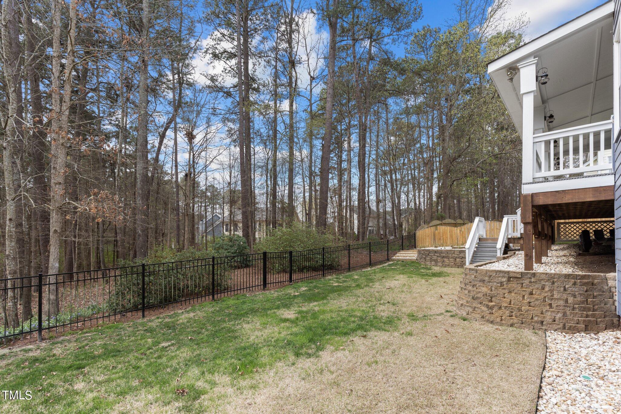 103 Summerglow Court Cary, NC 27513 - Photo 56 of 67 a view of backyard with a table and chairs and iron fence
