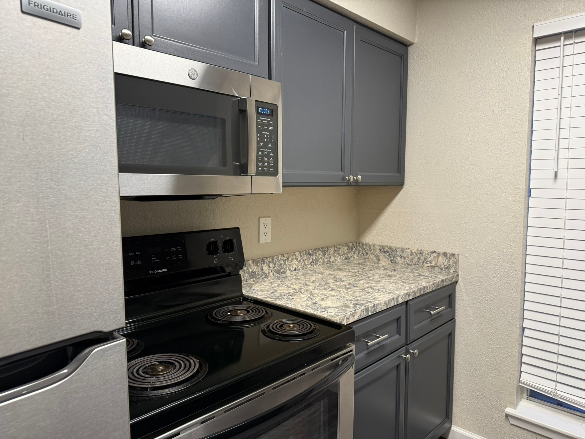 16303 Lyons School Road, Unit 907 Spring, TX 77379 - Photo 5 of 21 a kitchen with a stove and a microwave