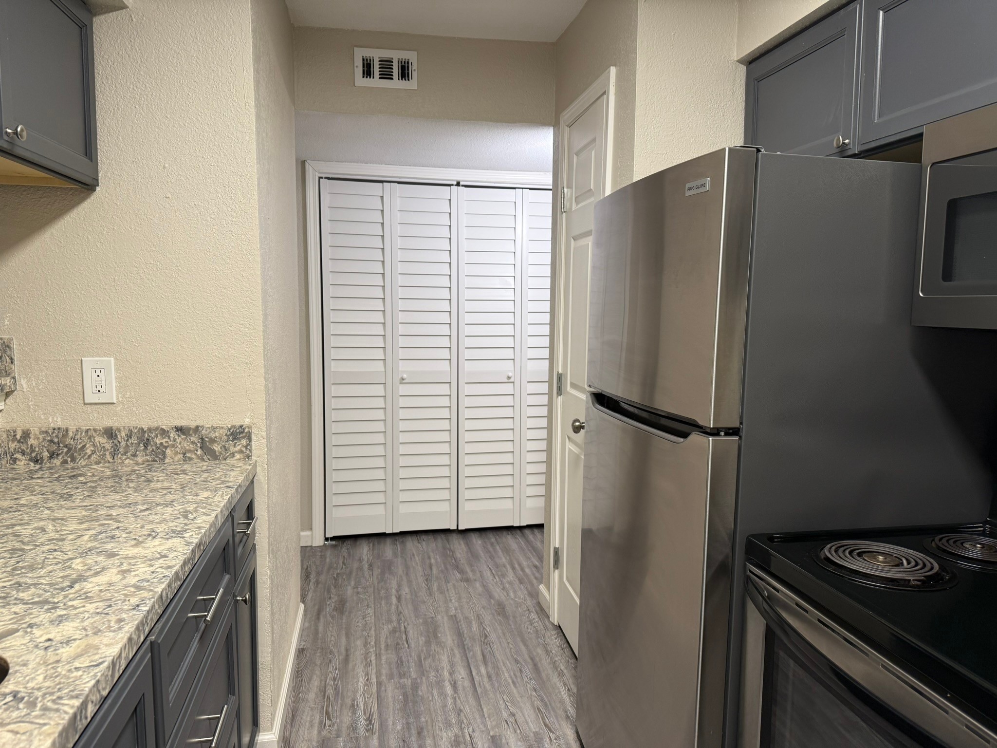 16303 Lyons School Road, Unit 907 Spring, TX 77379 - Photo 7 of 21 a kitchen with a refrigerator and a stove top oven