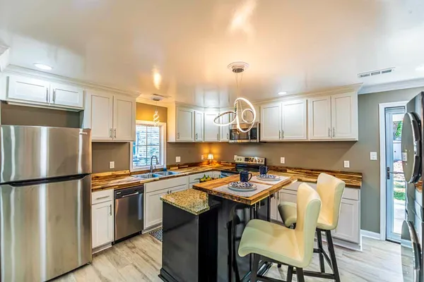 a kitchen with a sink a kitchen island and stainless steel appliances