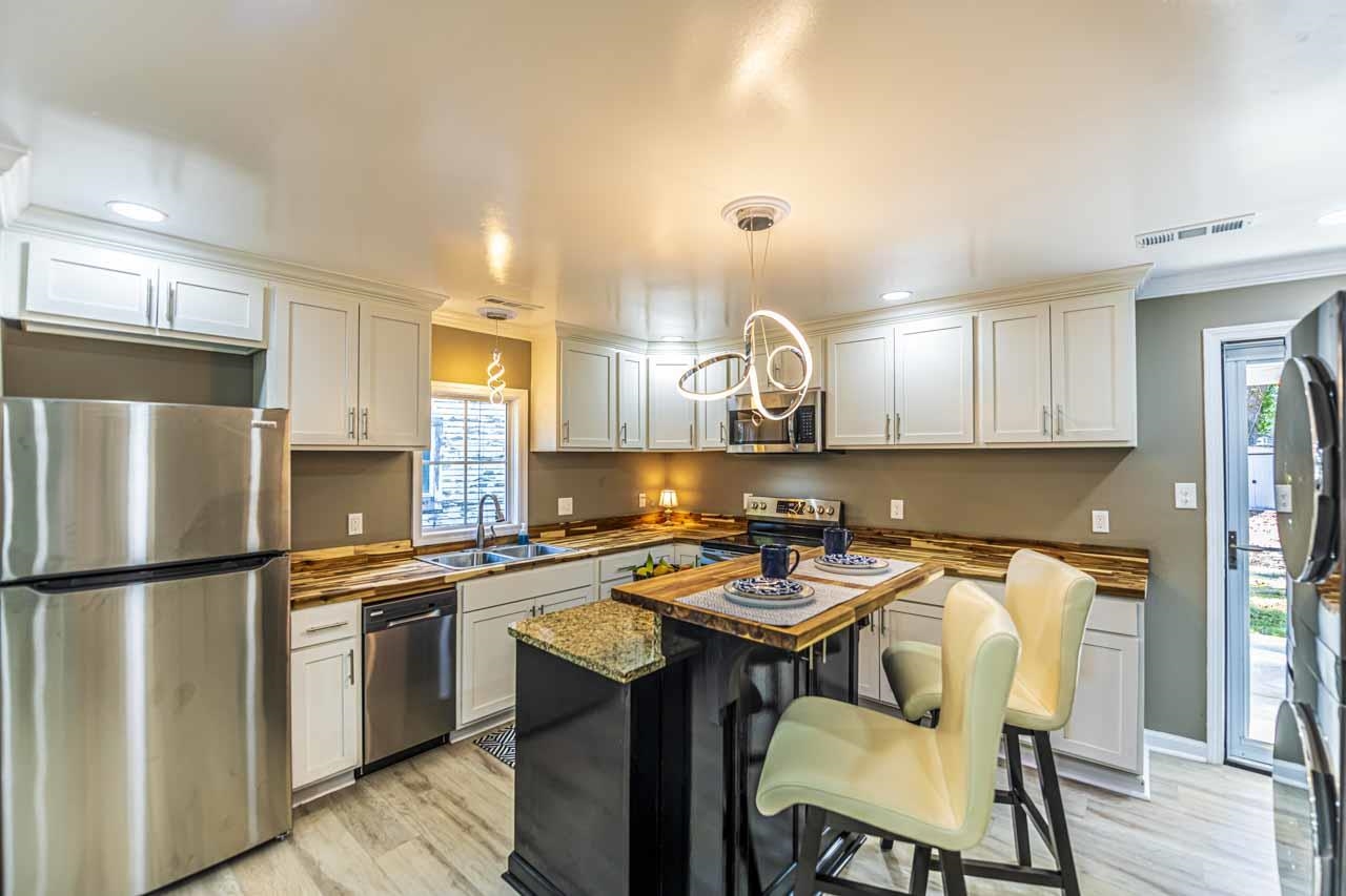 715 South Maple Street Covington, TN 38019 - Photo 17 of 33 a kitchen with a sink a kitchen island and stainless steel appliances