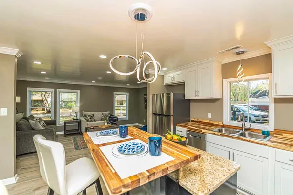a view of a dining room with furniture a chandelier and wooden floor