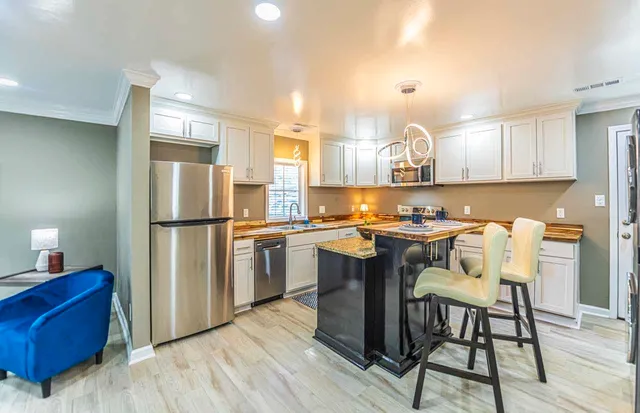 a kitchen with a refrigerator a counter space and appliances