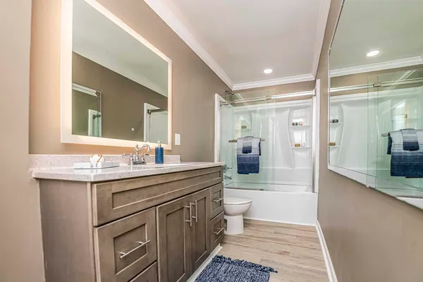 a bedroom with a bed and a lamp on dresser