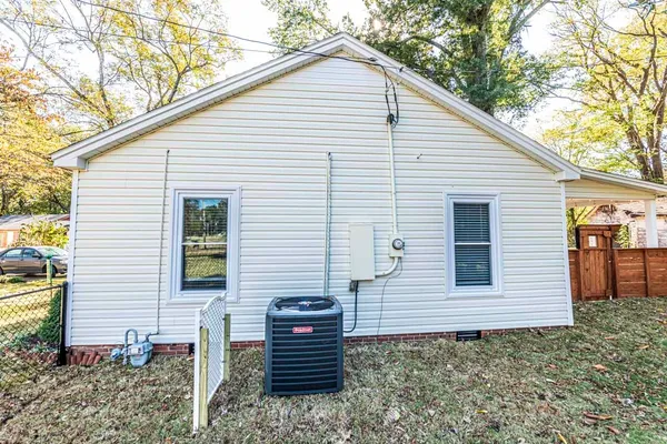 a view of a house with a small yard and wooden fence