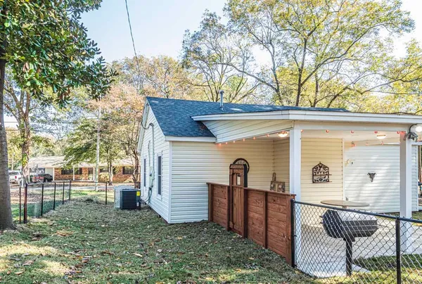 a view of a house with backyard and a tree