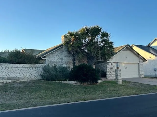 a front view of house with a garden