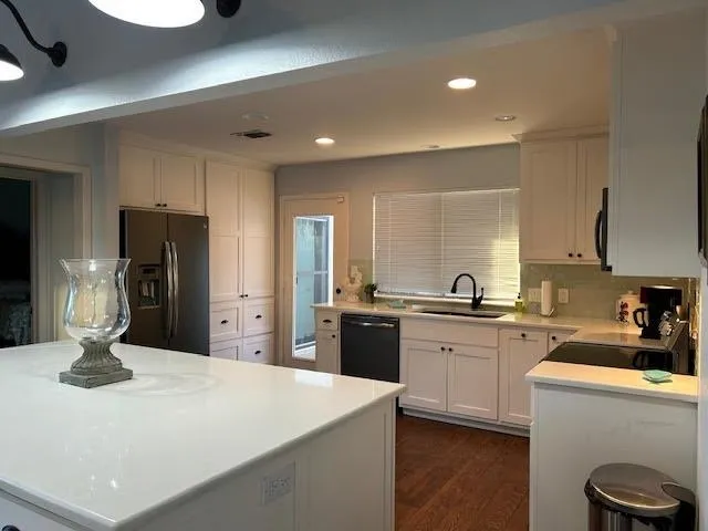 a kitchen with stainless steel appliances a sink stove and refrigerator