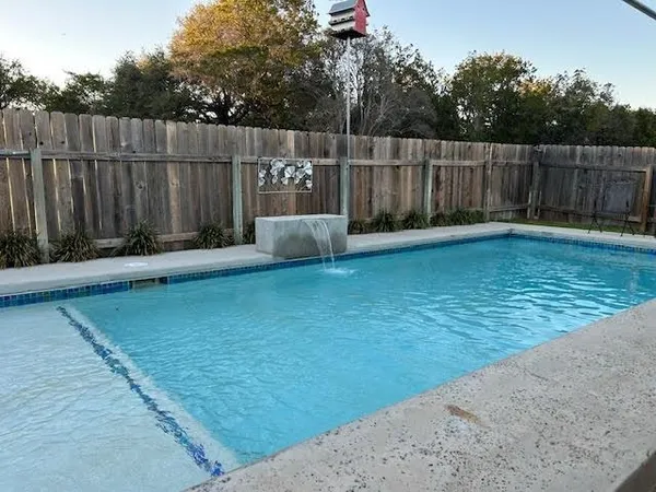 a view of a backyard with wooden fence