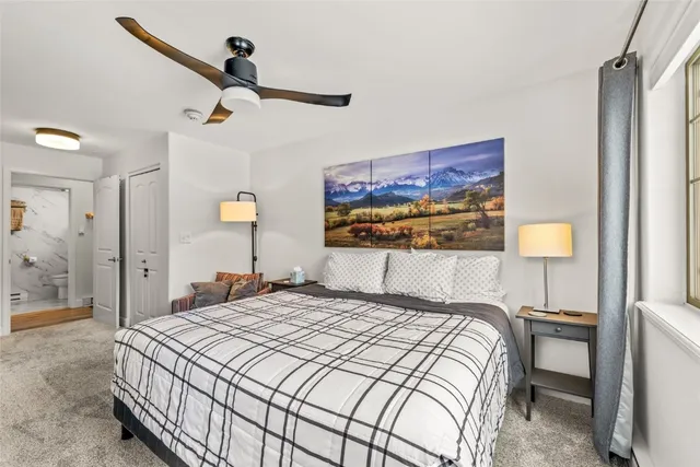 a bedroom with a bed and a painting on the wall