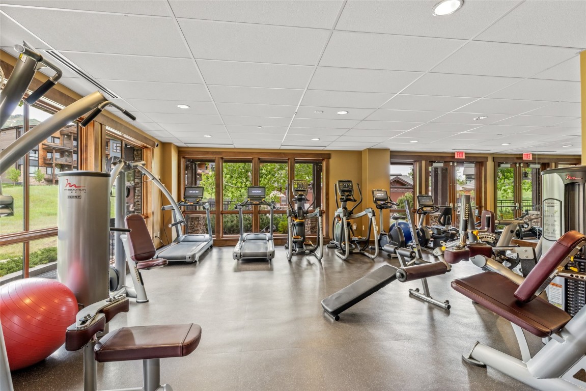 2545 Cattle Kate Circle, Unit 3207 Steamboat Springs, CO 80487 - Photo 24 of 42 a living room with furniture a rug floor to ceiling windows and a flat screen tv