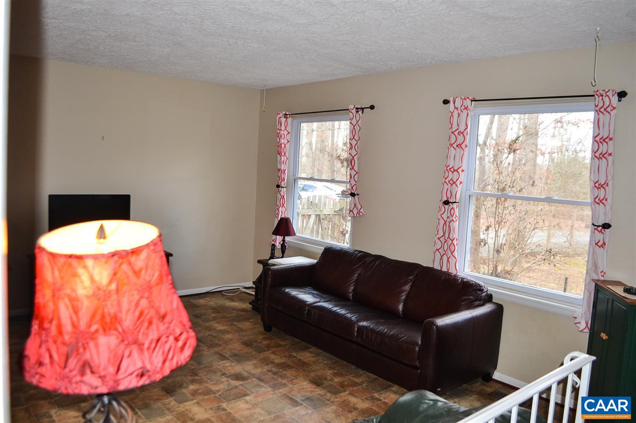 2738 Rio Mills Road Earlysville, VA 22936 - Photo 39 of 48 a living room with furniture a large window and a chandelier