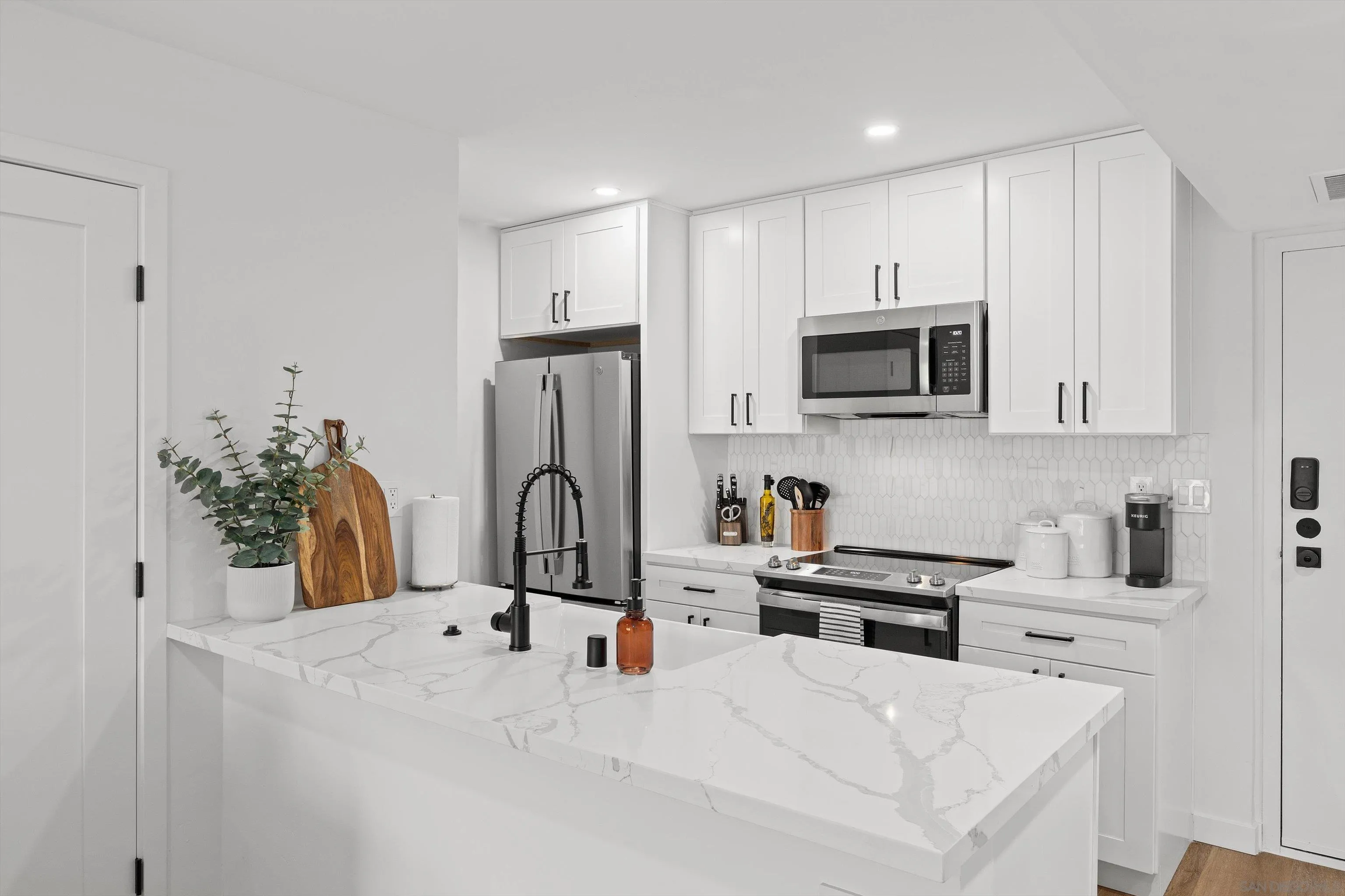 6111 Rancho Mission Road, Unit 313 San Diego, CA 92108 - Photo 3 of 25 a kitchen with stainless steel appliances a microwave a sink a refrigerator and cabinets