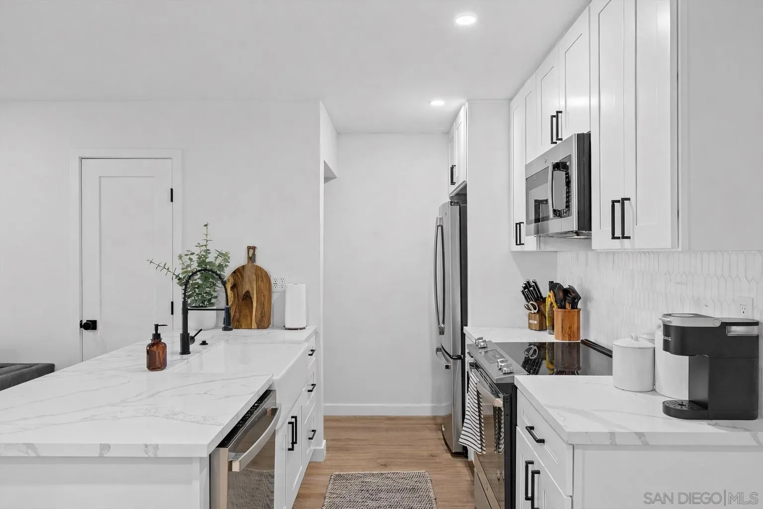 6111 Rancho Mission Road, Unit 313 San Diego, CA 92108 - Photo 7 of 25 a kitchen with a sink refrigerator and microwave