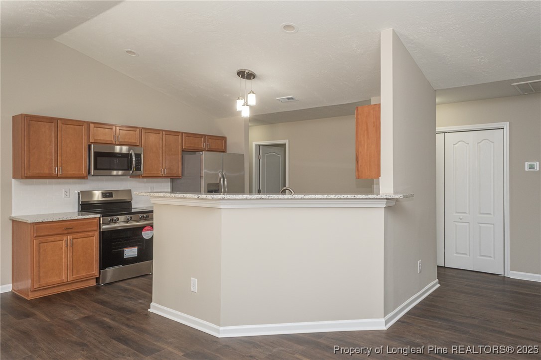 2830 John McMillan Road Hope Mills, NC 28348 - Photo 13 of 46 a kitchen with stainless steel appliances granite countertop a refrigerator a stove top oven a sink and dishwasher with wooden floor