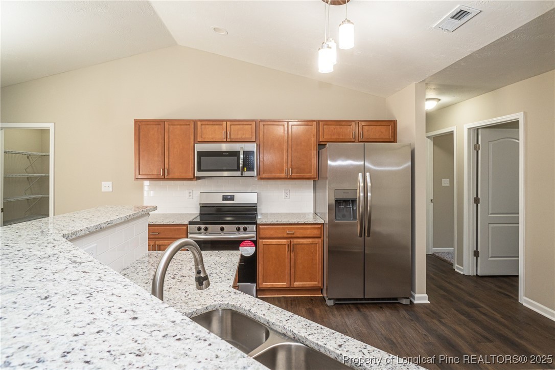 2830 John McMillan Road Hope Mills, NC 28348 - Photo 15 of 46 a kitchen with stainless steel appliances granite countertop a refrigerator stove and sink