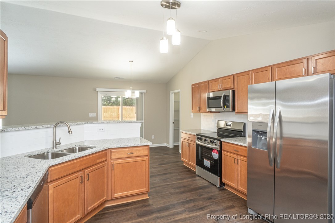 2830 John McMillan Road Hope Mills, NC 28348 - Photo 16 of 46 a kitchen with stainless steel appliances granite countertop a sink a stove and refrigerator