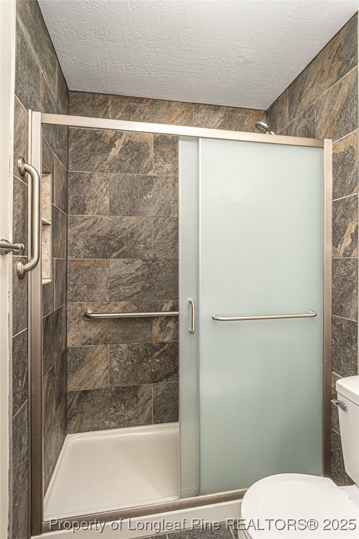 2830 John McMillan Road Hope Mills, NC 28348 - Photo 29 of 46 a bathroom with a shower a toilet and a sink