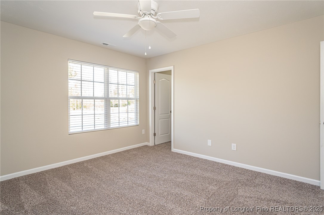 2830 John McMillan Road Hope Mills, NC 28348 - Photo 32 of 46 an empty room with chandelier fan and windows