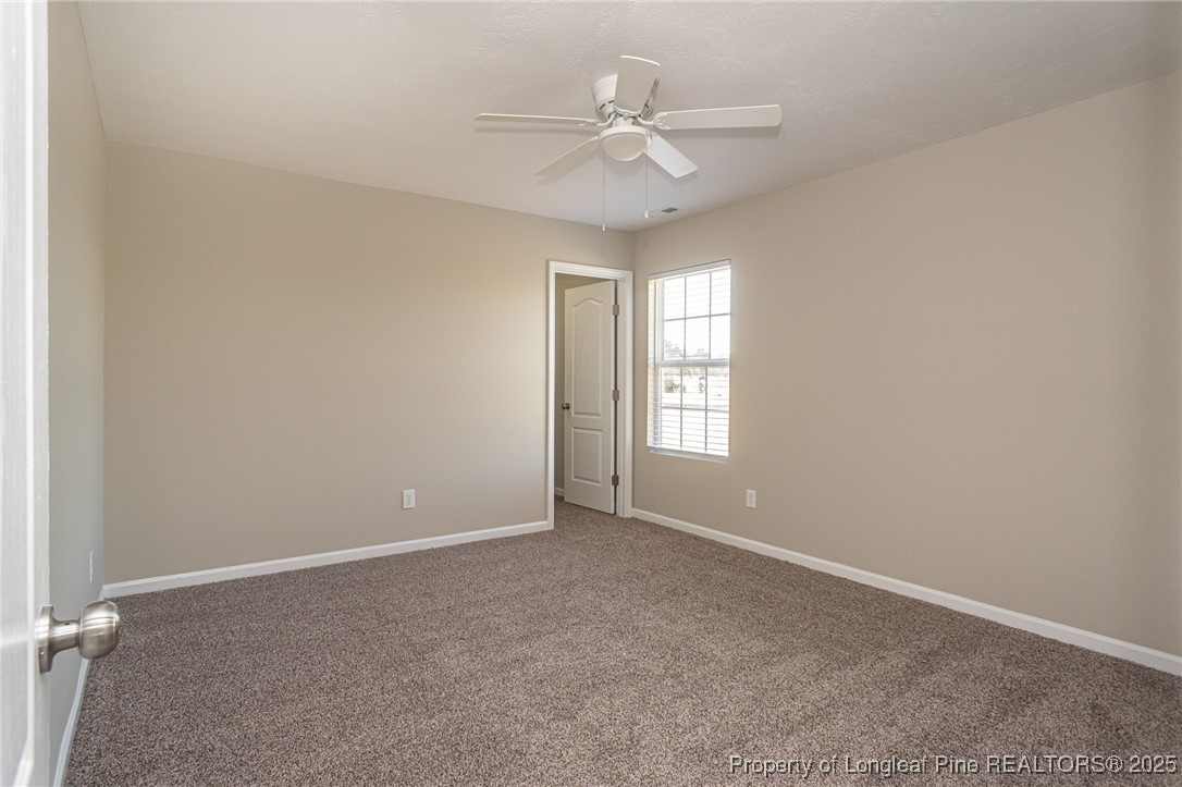 2830 John McMillan Road Hope Mills, NC 28348 - Photo 38 of 46 an empty room with windows and ceiling fan
