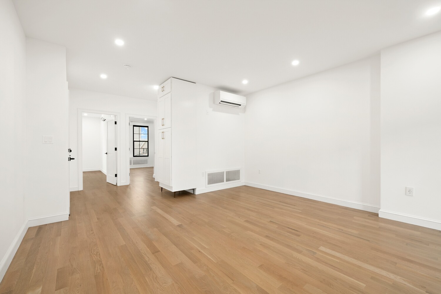 a view of an empty room with wooden floor