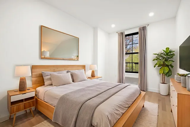 a bedroom with a balcony a bed and a flat screen tv