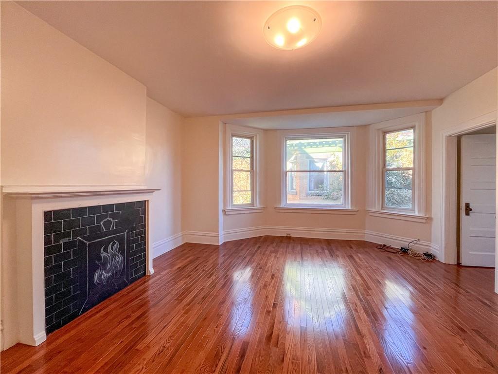 926 Savannah Avenue, Unit 2 Regent Square, PA 15221 - Photo 2 of 13 an empty room with wooden floor fireplace and windows