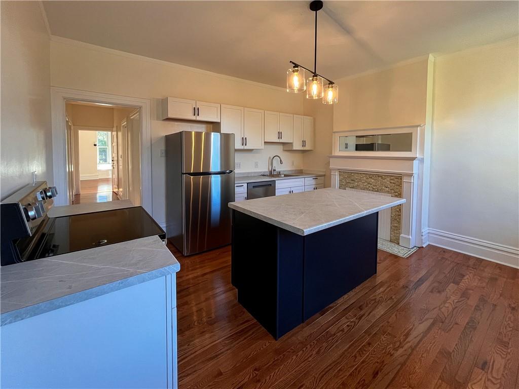 926 Savannah Avenue, Unit 2 Regent Square, PA 15221 - Photo 4 of 13 a kitchen with stainless steel appliances granite countertop a refrigerator a sink dishwasher a kitchen island with wooden floor and cabinets