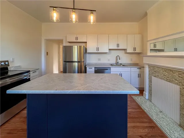 a large kitchen with kitchen island a sink stainless steel appliances and cabinets