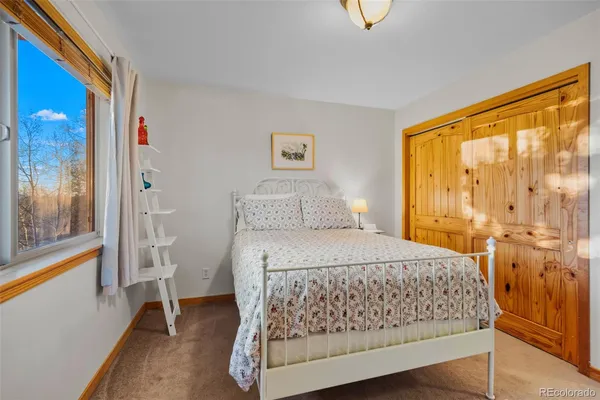 a bedroom with a bed and a dresser next to a window