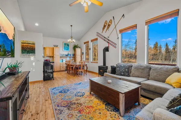 a living room with furniture a wooden floor and a chandelier