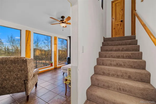 a view of staircase with lots of frames on wall and a large window