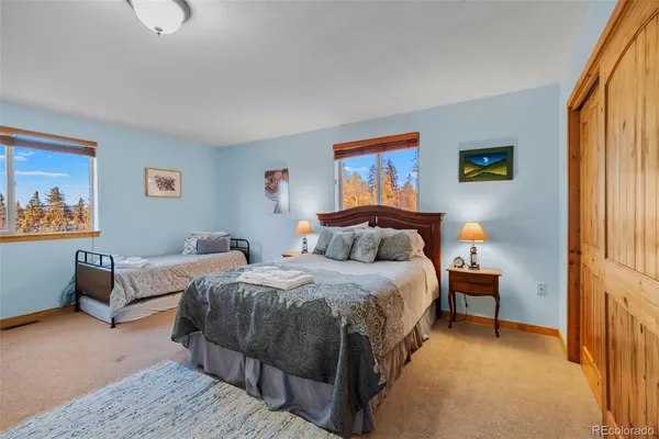 a bedroom with bed a couch and a window