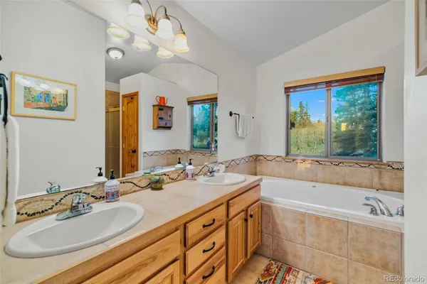 a bathroom with a tub sink and mirror